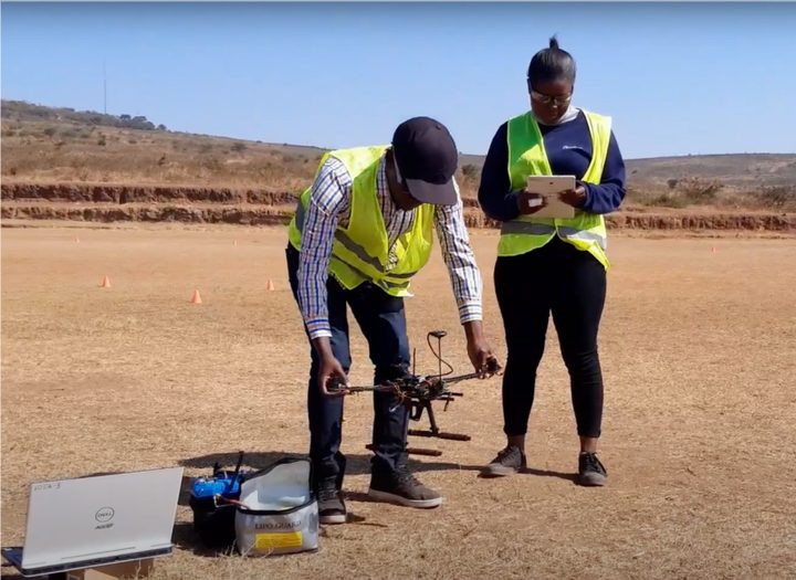 Two Epsilon team members preparing a drone for flight